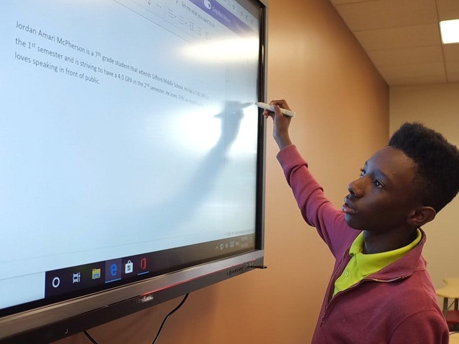 GYAC middle schooler writing on the white board